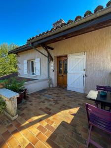 a house with a white door and a patio at Appartement 2 chambres avec terrasse in Polliat