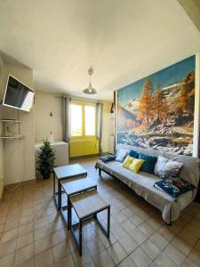 a living room with a couch and a painting on the wall at Appartement 2 chambres avec terrasse in Polliat +40 photos