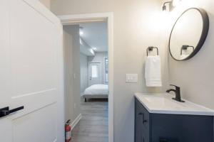 a bathroom with a sink and a mirror at Modern LUX 2BR Apartment in DC with Patio in Washington +9 photos