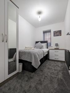 una camera da letto con un letto e una cabina doccia di CLARITURF - 4 Bedroom Semi - Private Parking near Turf Moor, Town Centre, Transport and Motorway Links next to Canal, 3 Parks and Lake - Sky and Netflix a Burnley