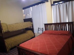 Un dormitorio con una cama y una silla y una ventana. en Chalet Paloma 2, en La Falda