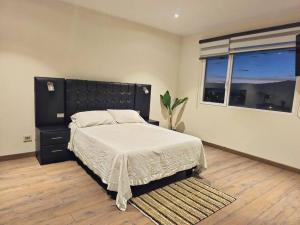 a bedroom with a large bed and a window at Comodo y equipado departamento en la Av Juan de la Rosa in Calacala +25 photos