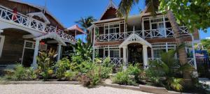 une maison sur la plage avec des fleurs devant dans l'établissement Caye Caulker Boutique Guesthouse 3, à Caye Caulker