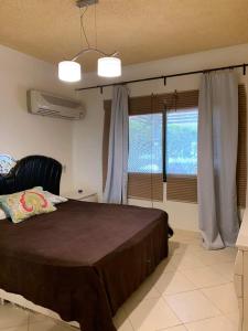 a bedroom with a bed and a large window at La hacienda Ras Sedr in Raʼs Matarma