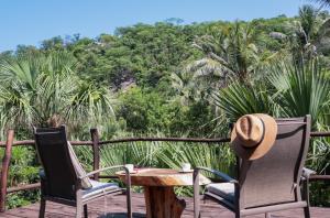 Una mesa y sillas en una terraza con árboles. en Black Sand Hotel Boutique, en Zapotal 76 fotos más