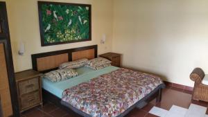 a bedroom with a bed and a painting on the wall at Ayu Taman Sari in Candidasa
