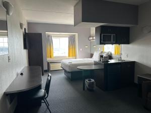 a hotel room with a bed and a kitchen at Microtel Inn & Suites by Wyndham Quincy Downtown - River Area in Quincy