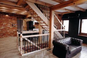 a living room with a staircase and a leather couch at Apartamenty Chrobrego 10 in Złotów