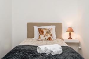 a bedroom with a bed with two towels on it at Atouguia House - Traditional House in Calheta