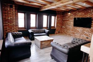 a living room with leather furniture and a tv at Apartamenty Chrobrego 10 in Złotów