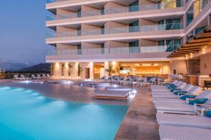 a hotel with a pool and lounge chairs at Hilton Santa Marta in Santa Marta