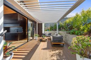 a patio with a couch and a table at On Point House, Luxury design, Water Views in Raglan