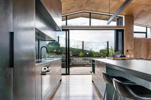 a kitchen with stainless steel appliances and a large window at On Point House in Raglan +22 photos