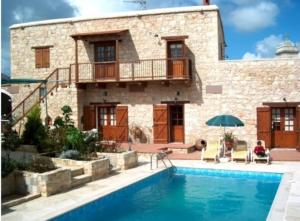 a house with a swimming pool in front of a building at Sappho Manor House in Drousha