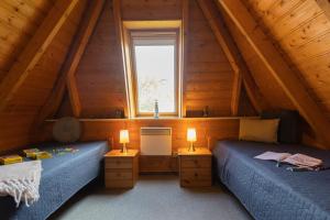 1 Schlafzimmer mit 2 Betten in einem hölzernen Dachgeschoss in der Unterkunft Ferienhaus Westertill 03 in Dorum Neufeld