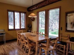a dining room with a wooden table and chairs at Paradise Valley Oasis - Your Yellowstone Base Camp in Flying Y Ranch Airport