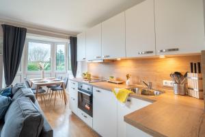 a kitchen with white cabinets and a table and a couch at Appartement "Wattenruh" Cappel Whg 4 in Cappel-Neufeld