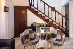 un salon avec deux chaises et un escalier dans l'établissement Rosehill Heights Modern 4 bedroom vacation rental, à Soufrière