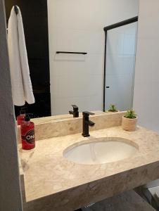 a bathroom counter with a sink and a mirror at Chalés Vista dos Carvalhos in Capitólio +27 photos