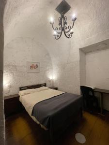 Un dormitorio con una cama y una lámpara de araña. en Habitación en Centro histórico, en Arequipa