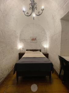 1 dormitorio con 1 cama en una habitación con lámpara de araña en Habitación en Centro histórico, en Arequipa