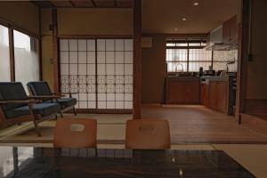 a living room with two chairs and a kitchen at CraftFlat Asakusa House in Tokyo