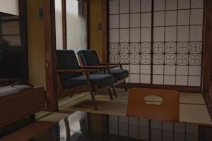 a waiting room with two chairs and a tv at CraftFlat Asakusa House in Tokyo