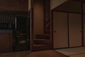 a room with a door leading to a kitchen and stairs at CraftFlat Asakusa House in Tokyo