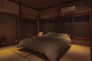 a bedroom with a bed and a air conditioner at CraftFlat Asakusa House in Tokyo