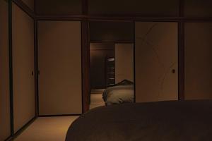 a bedroom with a bed and a large mirror at CraftFlat Asakusa House in Tokyo