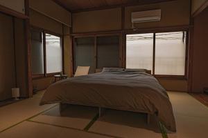 a bedroom with a bed in a room with windows at CraftFlat Asakusa House in Tokyo