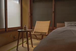 a bedroom with a chair and a bed and a table at CraftFlat Asakusa House in Tokyo