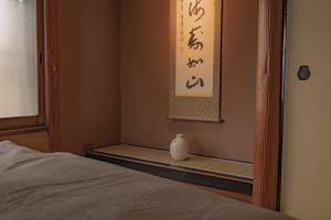 a room with a bed and a vase sitting on a shelf at CraftFlat Asakusa House in Tokyo