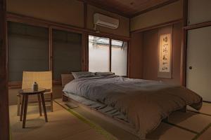 a bedroom with a bed and a table and a window at CraftFlat Asakusa House in Tokyo