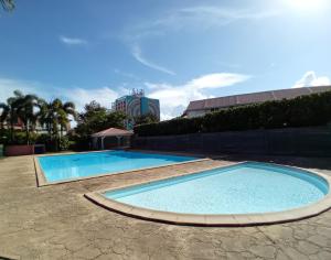 a swimming pool in a resort with a building in the background at Au bout du rêve - Le Gosier in Le Gosier