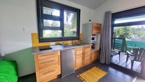 a kitchen with a sink and a large window at TAHITI - Mango Lodge Moana in Papara +6 photos
