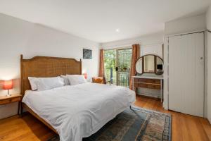 a bedroom with a large white bed and a window at Seaside Sanctuary in Saint Leonards