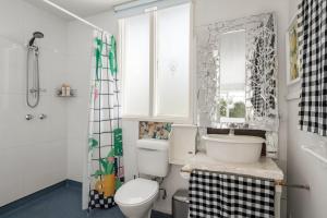 a bathroom with a toilet and a sink and a window at Seaside Sanctuary in Saint Leonards