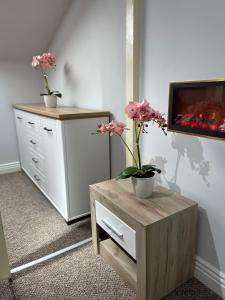 a room with two dressers with flowers on them at Milennium Apart Hotel in Bucharest