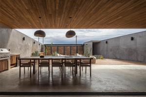 a dining room with a table and some chairs at Casa Malbec, Valle de Guadalupe in Valle de Guadalupe