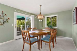 una sala da pranzo con tavolo, sedie e lampadario pendente di Cozy Redmond Retreat- Shared Home near Parks and Attractions a Redmond
