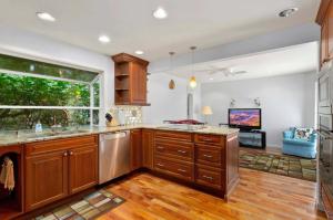 una cucina con armadi in legno e una grande finestra di Cozy Redmond Retreat- Shared Home near Parks and Attractions a Redmond