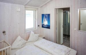 a bedroom with a white bed and a window at Friedrichskoog-Deichblick 6 in Friedrichskoog