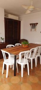 a wooden table with white chairs around it at Casa espaçosa pertinho da praia in Santos