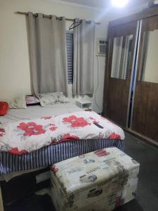 a bedroom with a bed and a box on the floor at Casa Tomazella in Guarujá