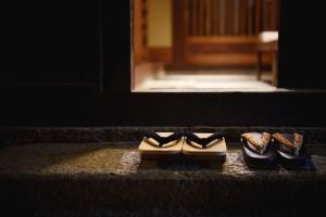 two pairs of shoes sitting on the floor in front of a door at Ubusuna no Sato TOMIMOTO in Ando