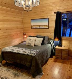 a bedroom with a bed and a chandelier at Yellowstone Cabin in Island Park- King bed with private bathroom and HOT TUB in Island Park