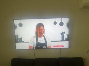 a tv screen on a wall with a woman on it at Urban Retreat in Wollongong