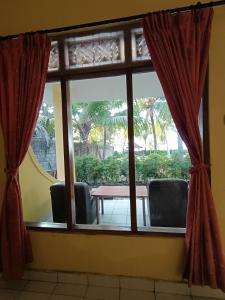 a room with a window with a table and chairs at Bungalow Mudri Lovina in Temukus