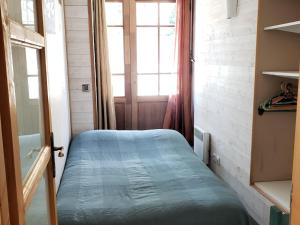 a small bedroom with a blue bed in a room at Appartement cosy 2 pièces, centre village, 4 pers, proche pistes et parc-luge - FR-1-515-216 in Villard-de-Lans